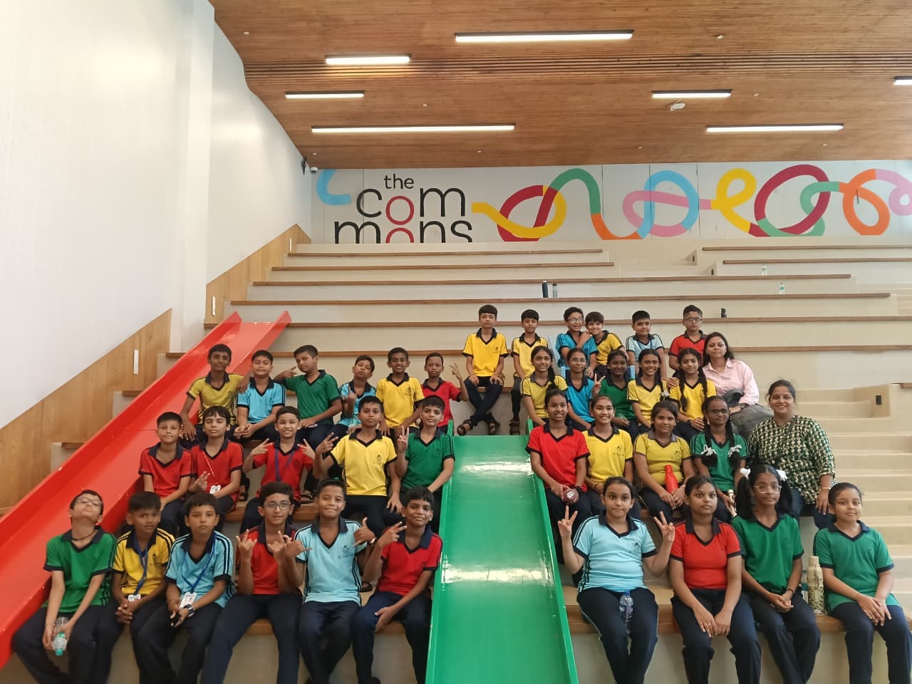 Students and teachers seated on steps during a picnic at The Commons