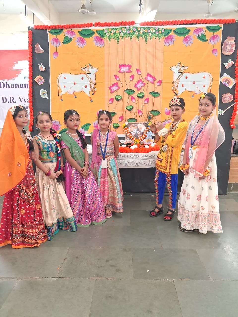 Students in traditional dress standing by a decorated festival altar